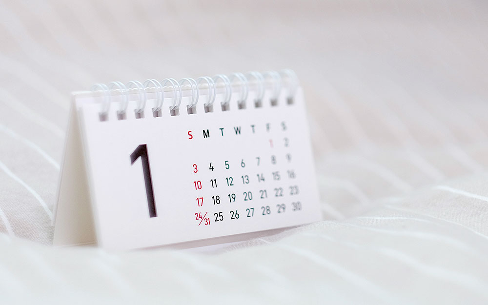 a small white calendar with a large number one sits on white fabric