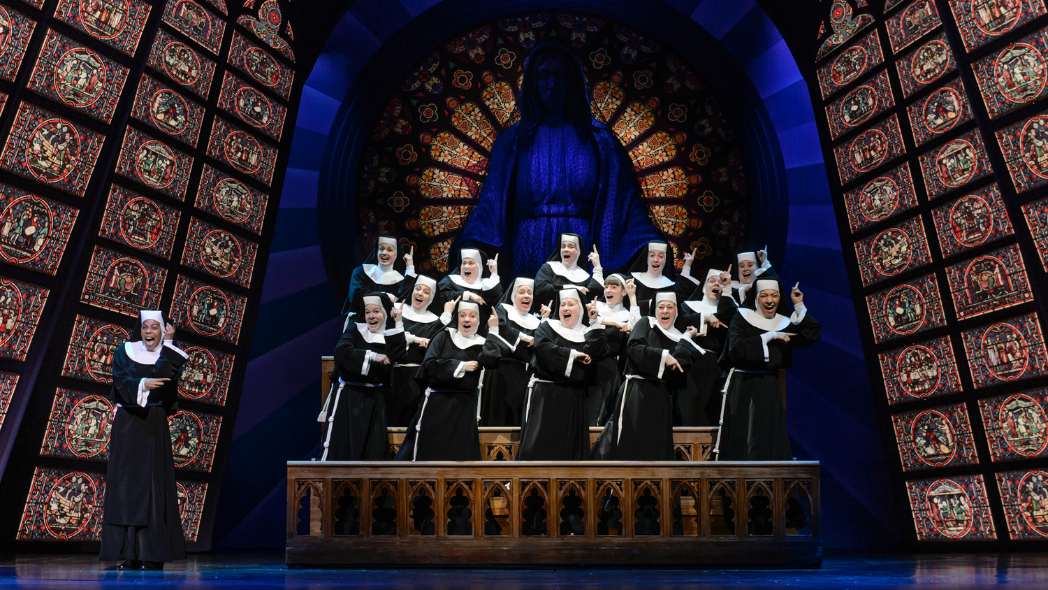 a group of actors dressed as nuns performing on stage
