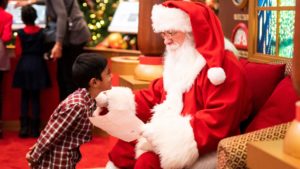 a young boy talks to Santa