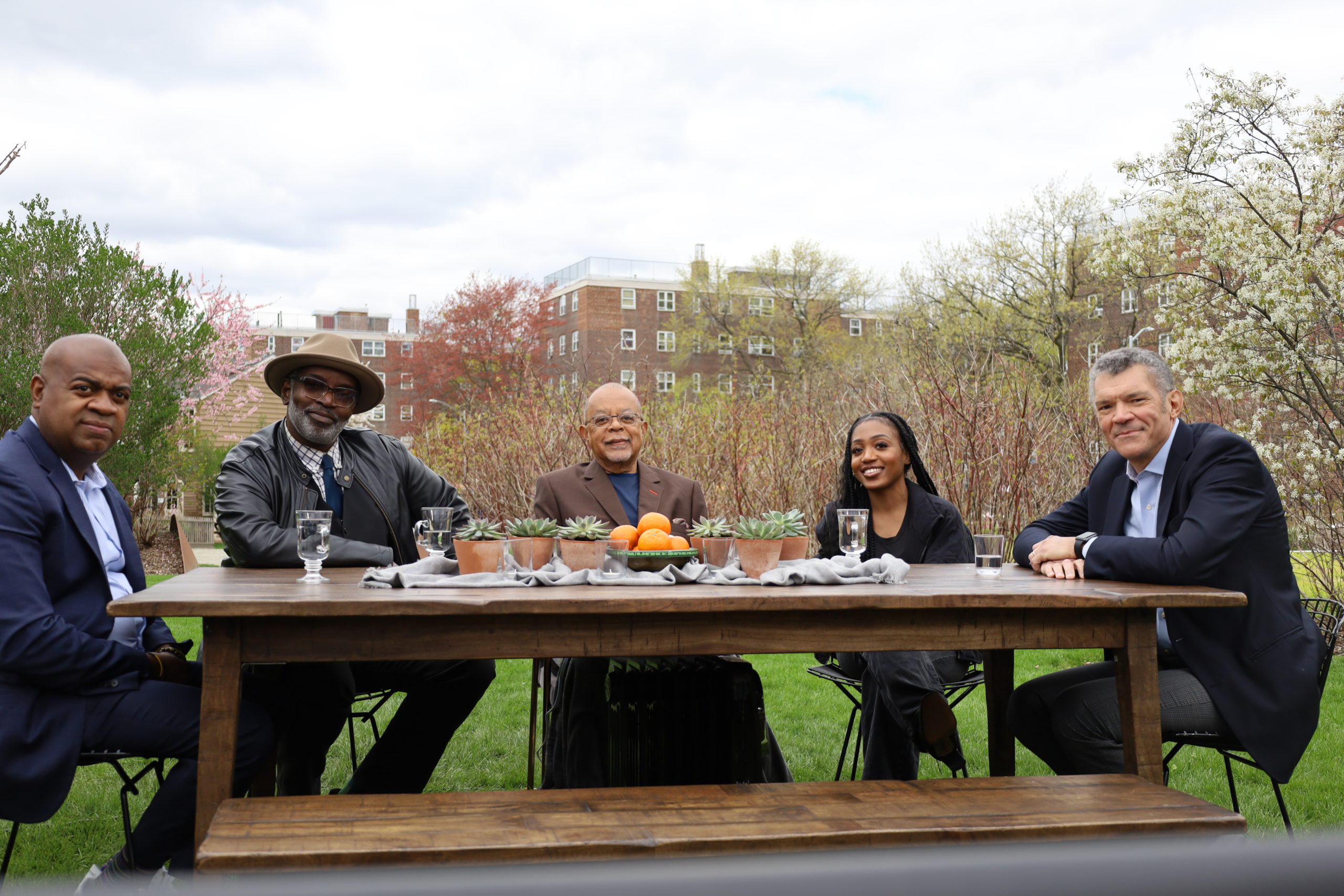 Five panelists from the TV program Making Black America sit around a table and smile at the camera.