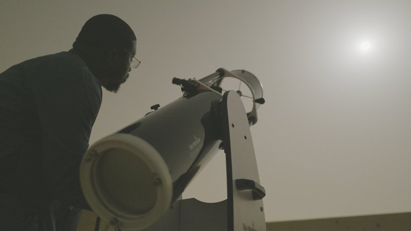 A star chaser looks through a telescope, as featured on NOVA on PBS.