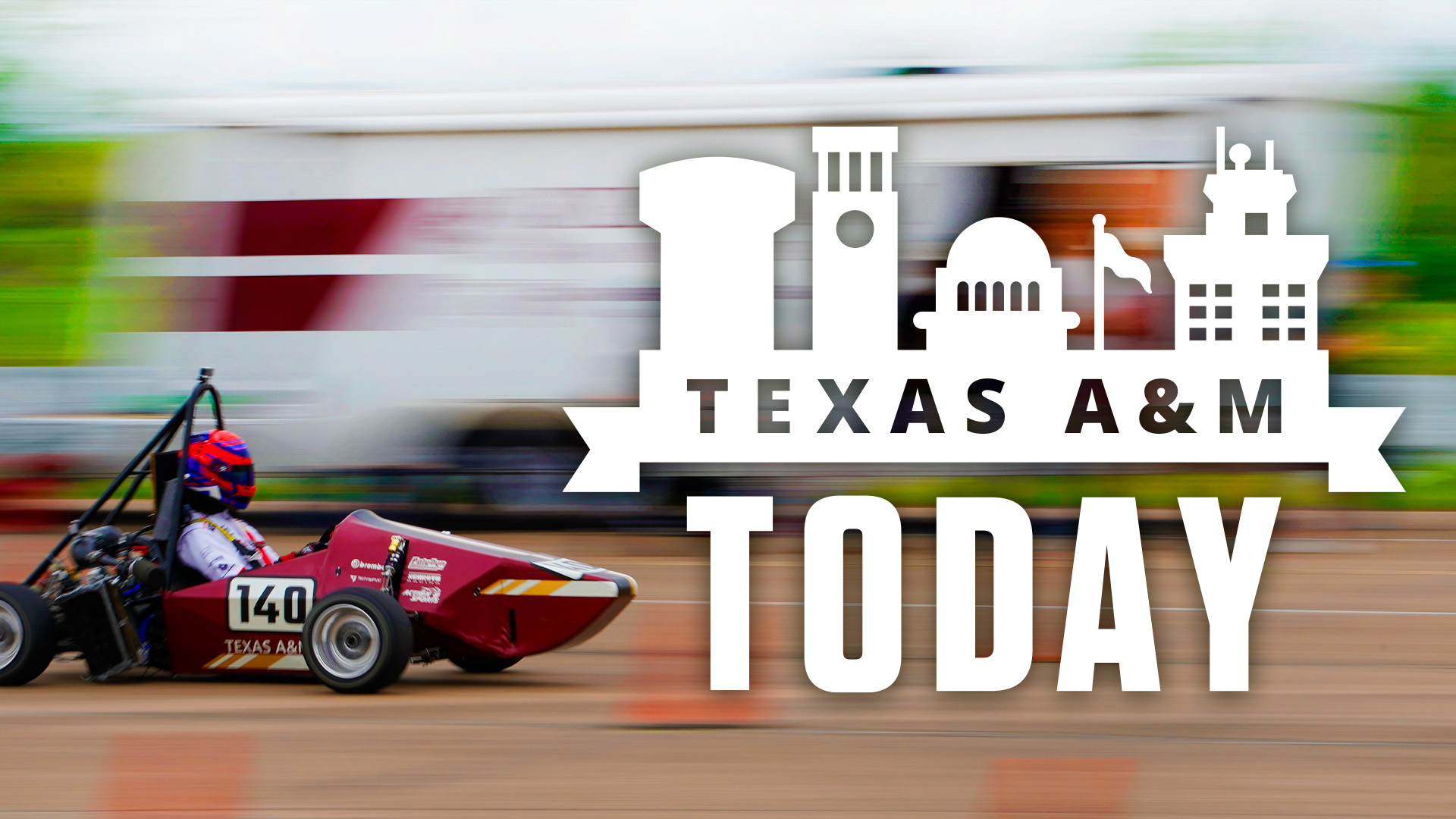 A race car drives past the camera with a logo for "Texas A&M Today."