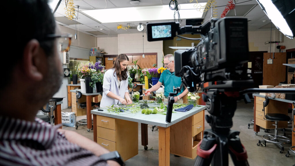Chelsea Reber and Bill McKinley are filmed while making floral arrangements.