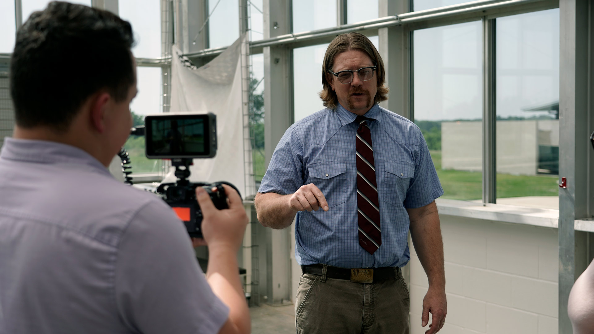 A crew member films a professor talking about corn breeding.