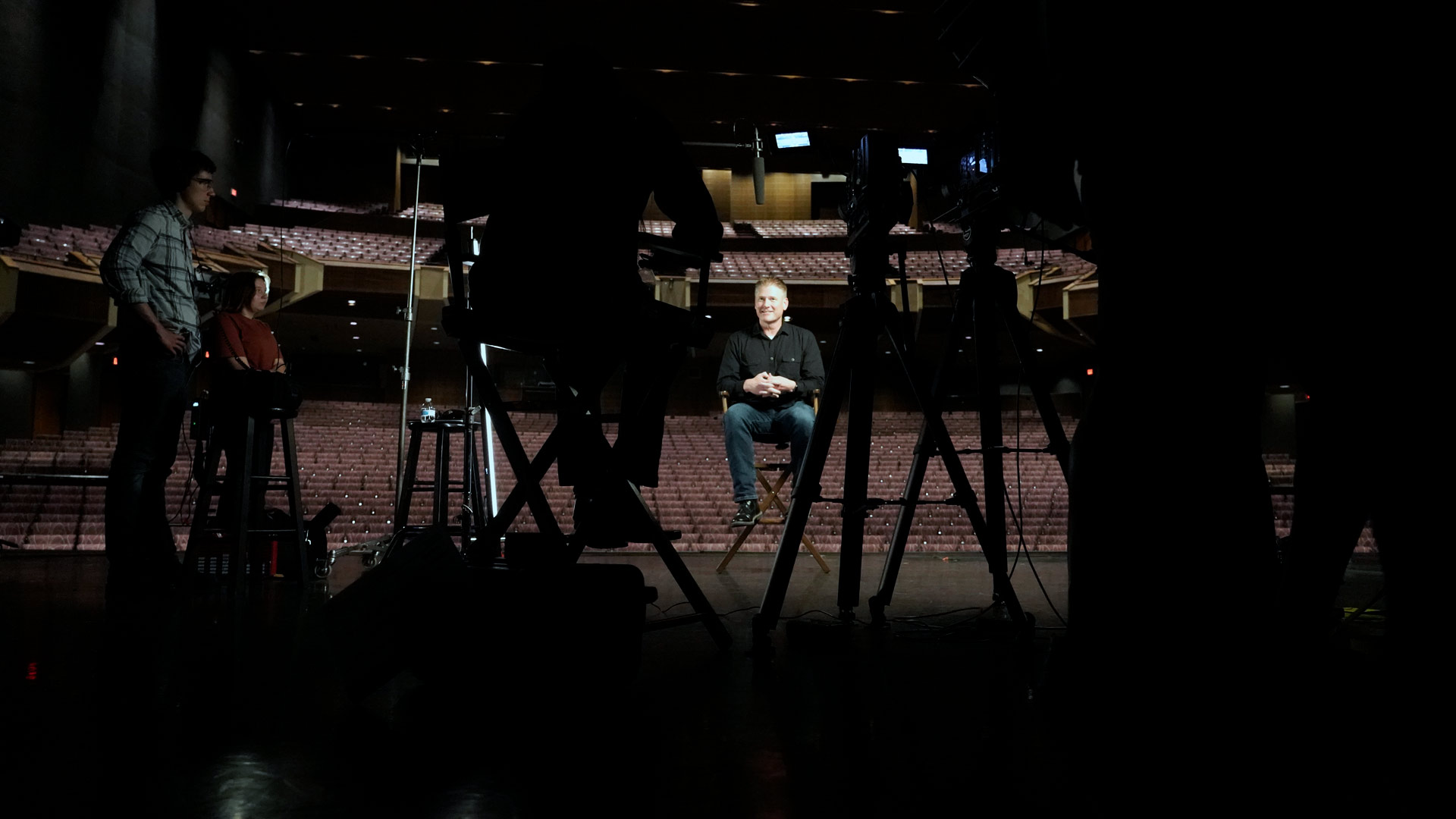 The cameras and crew watching an interview taking place on the Rudder Auditorium stage.