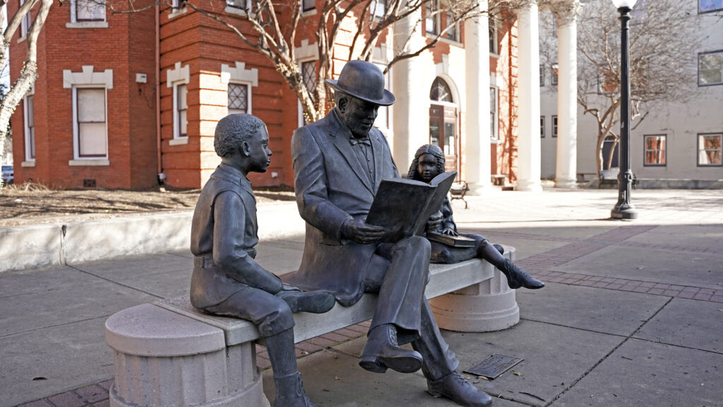 Statue of three people reading