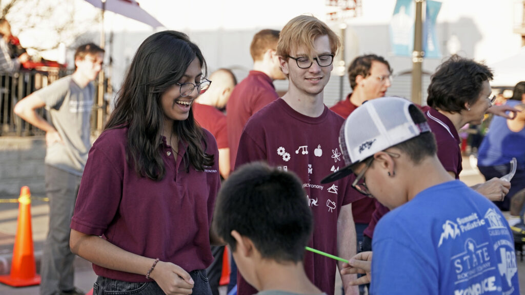 Texas A&M students interacting with visitors 