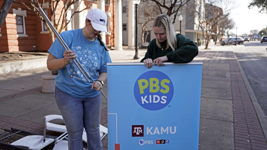 Alex and Emily setting up a PBS KIDS banner