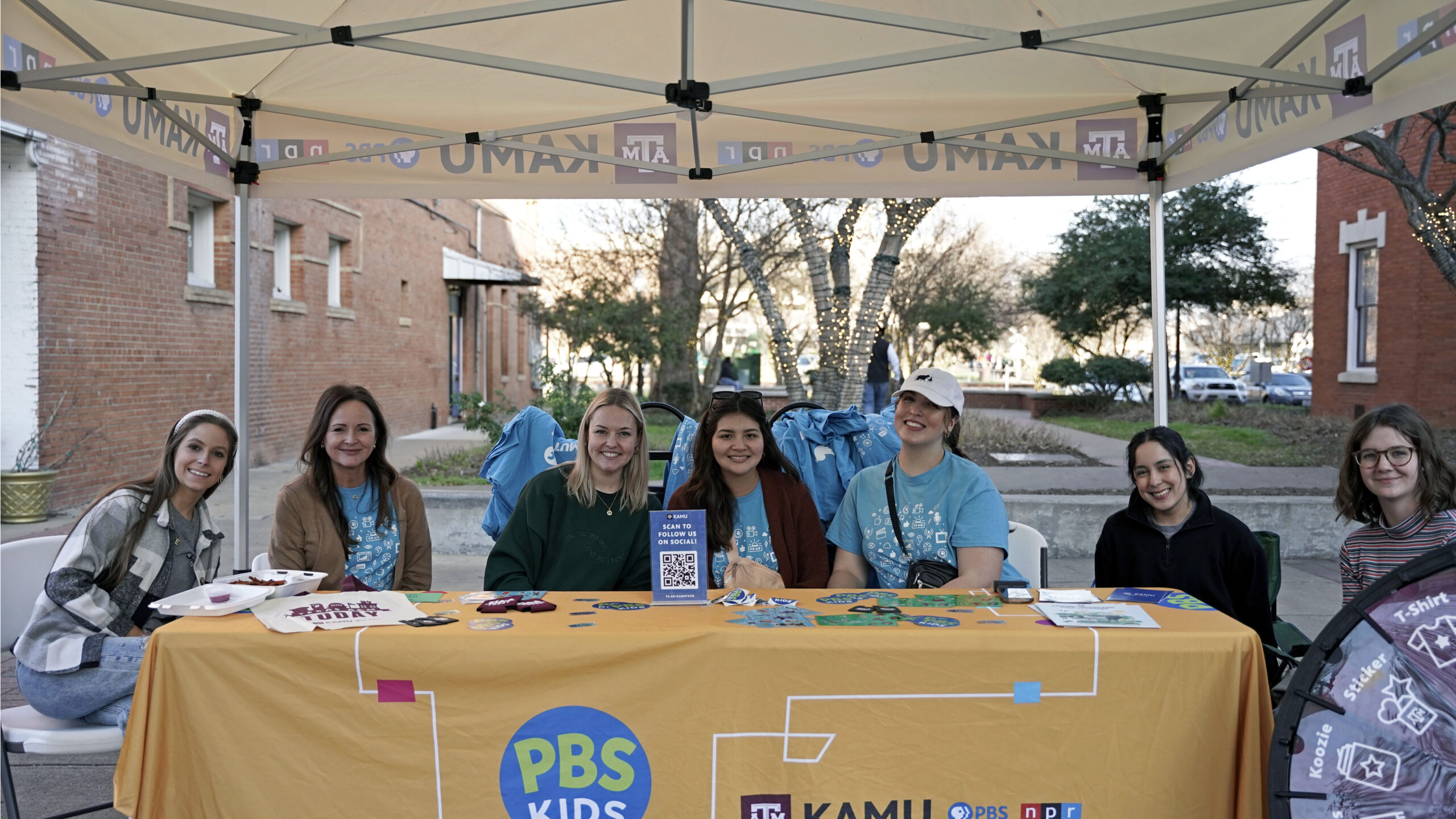 KAMU team sitting behind table during First Friday