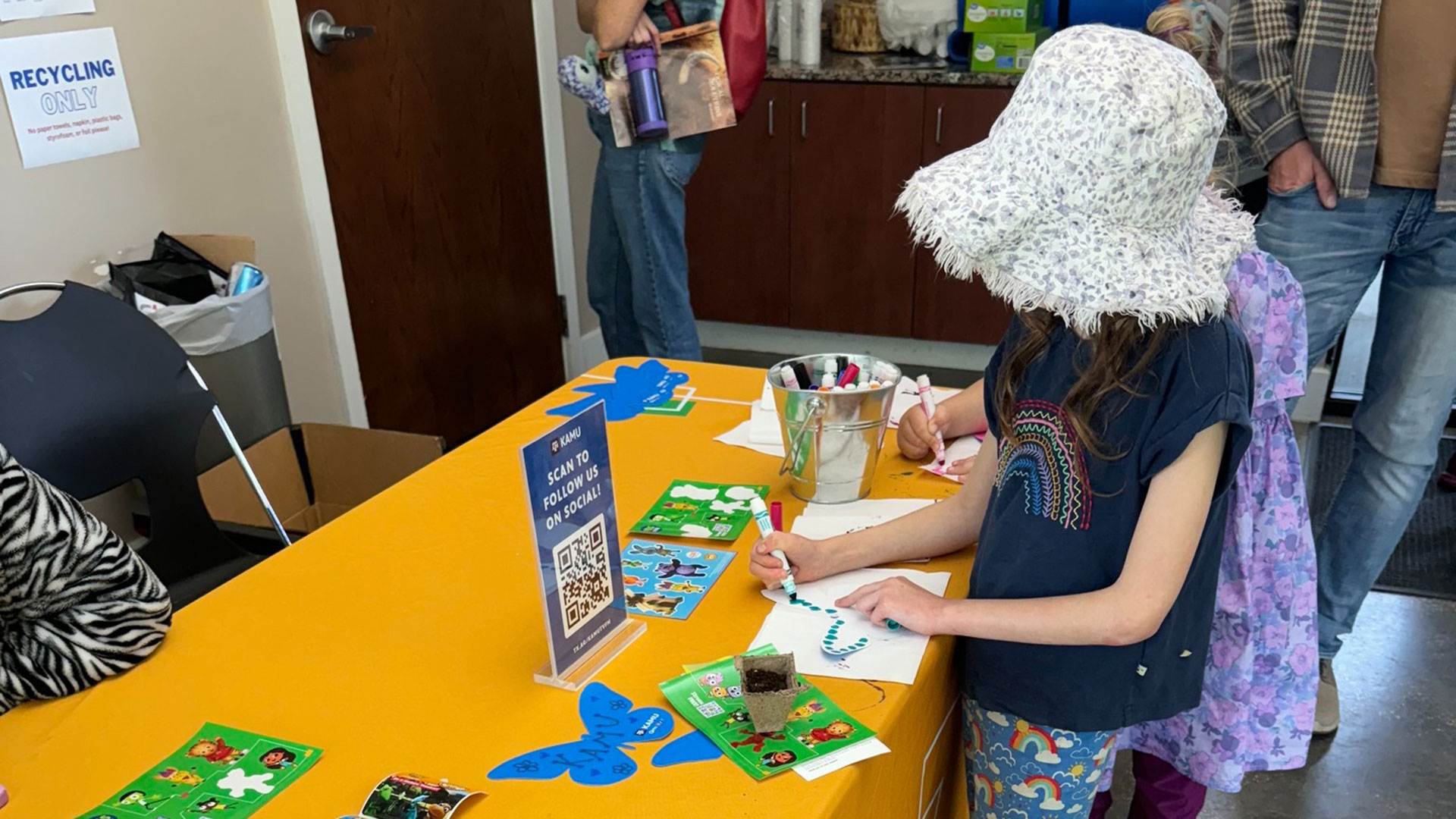 Children decorate paper butterflies with markers