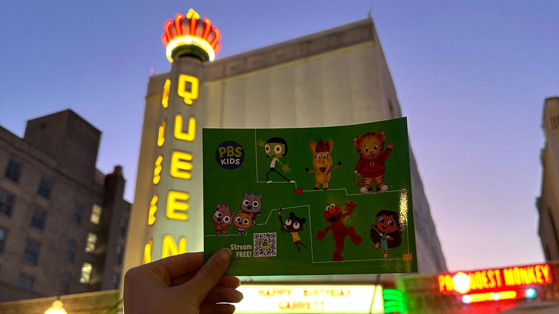 A PBS Kids sticker sheet in front of the Queen Theater in downtown Bryan