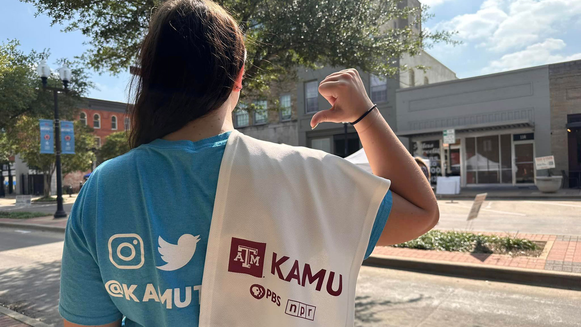 A KAMU staff member gestures to the KAMU-branded towel flung over her shoulder