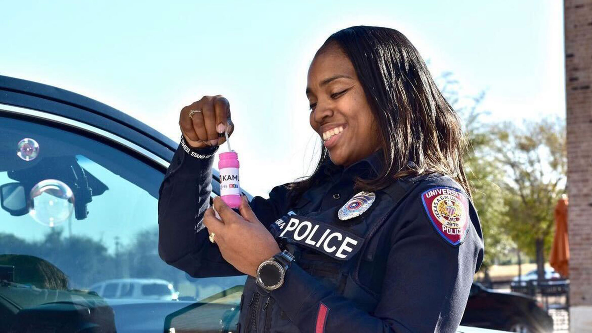 A university police officer plays with KAMU bubbles