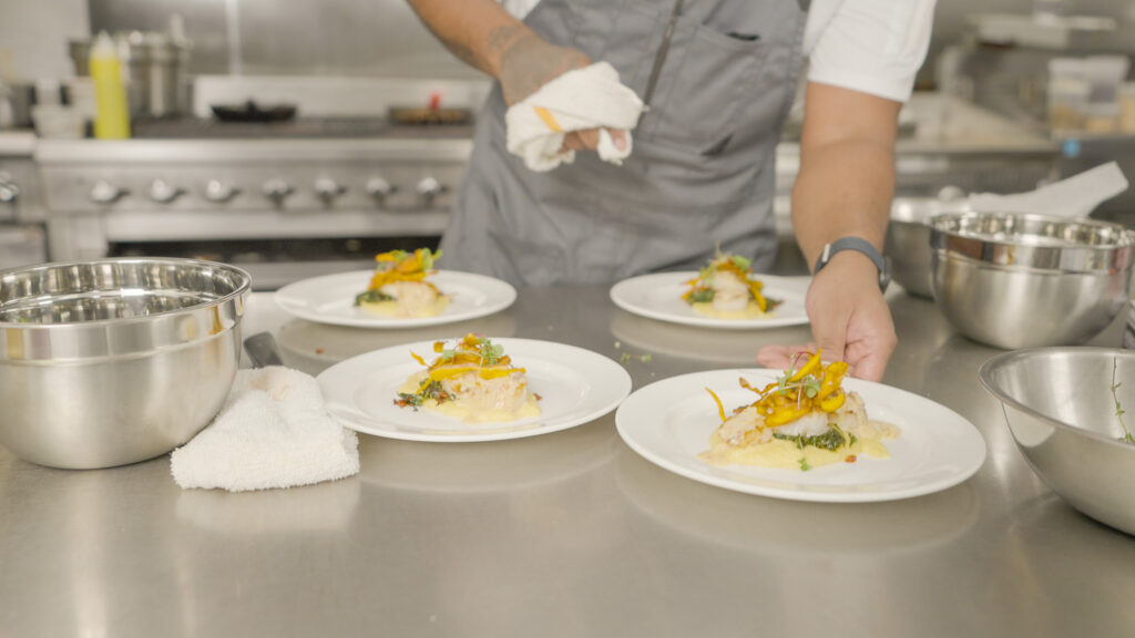 Chef Demetrius wipes off his plates.